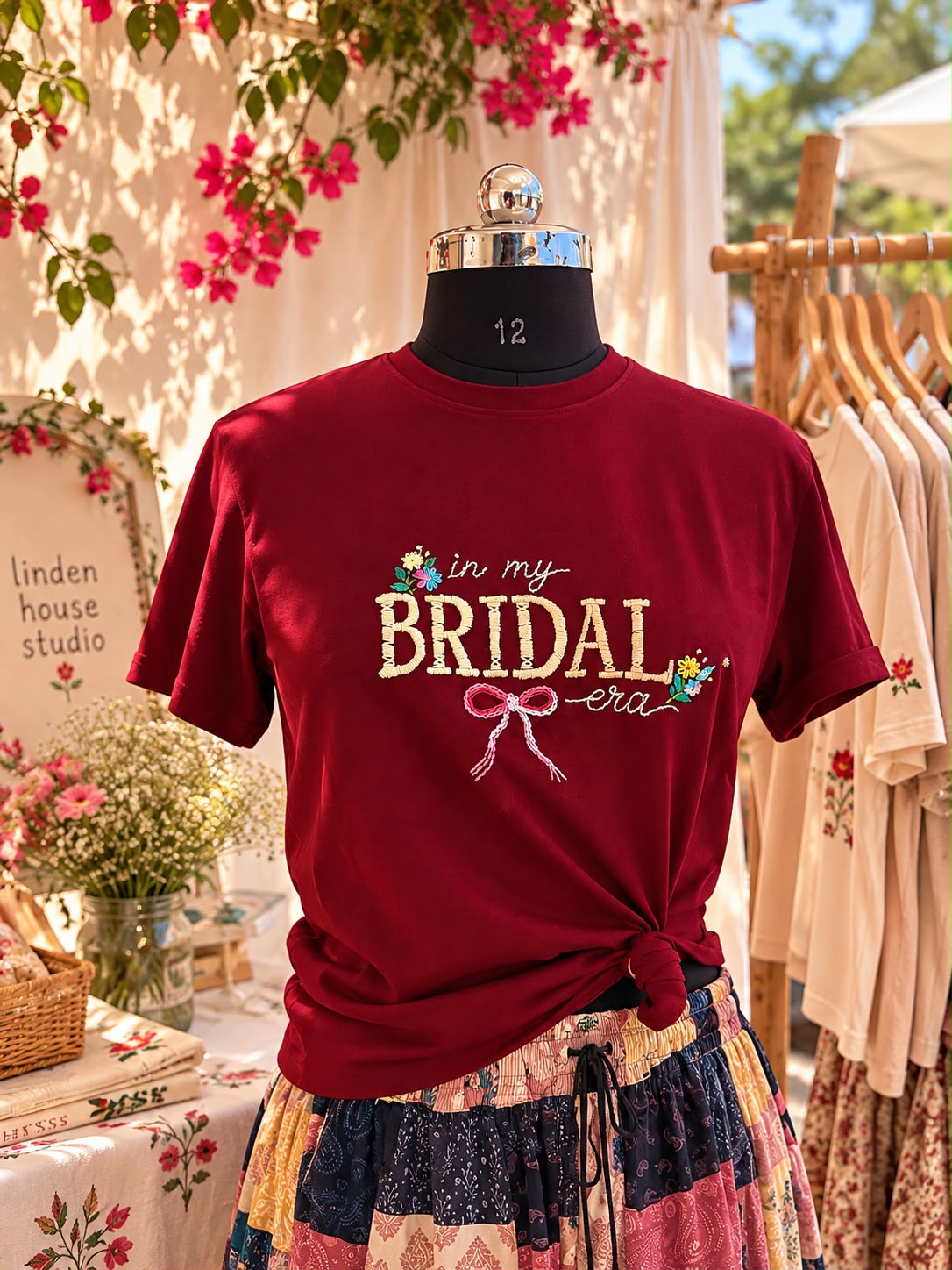 Maroon In My Bridal Era hand embroidered tee on a mannequin under bougainvillea at the Linden House stall